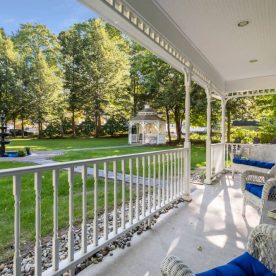 Private porch overlooking an expansive lawn with a fountain and gazebo